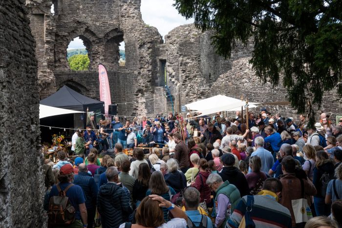 A crowd of people in Abergavenny food festival in a castle