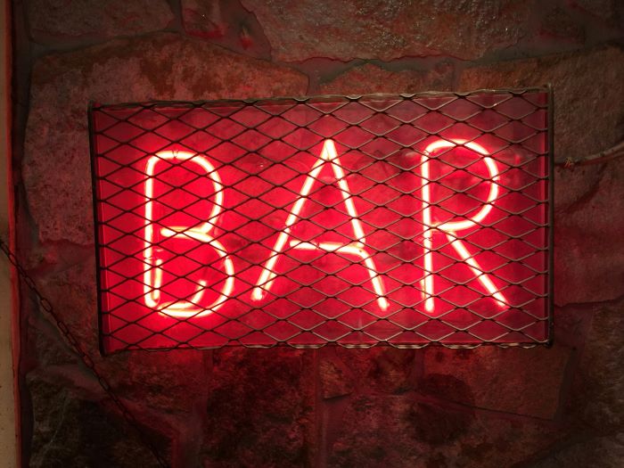 A neon red sign that says 'BAR'