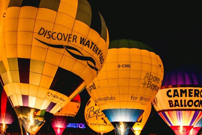 A bunch of lit hot air balloons in the sky