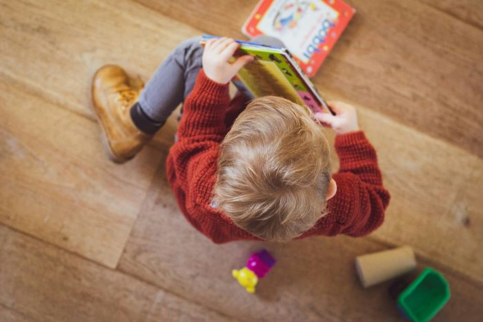 Child sitting on the floor with books