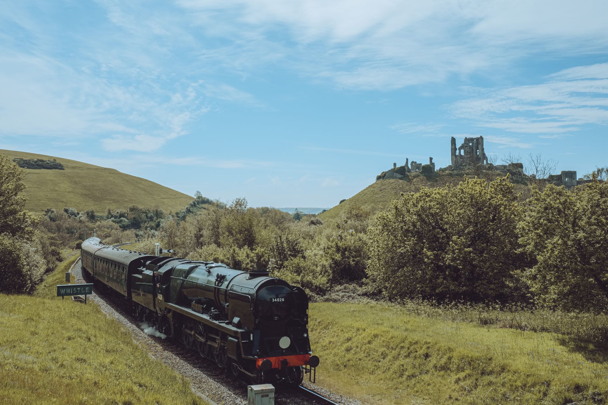 Locomotive moves beyond Corfe Castle in the background.