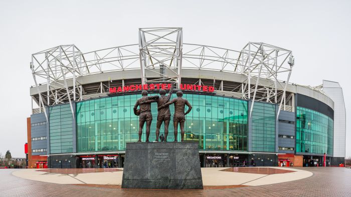 A statue of three footballers outside Old Trafford stadium in Manchester.