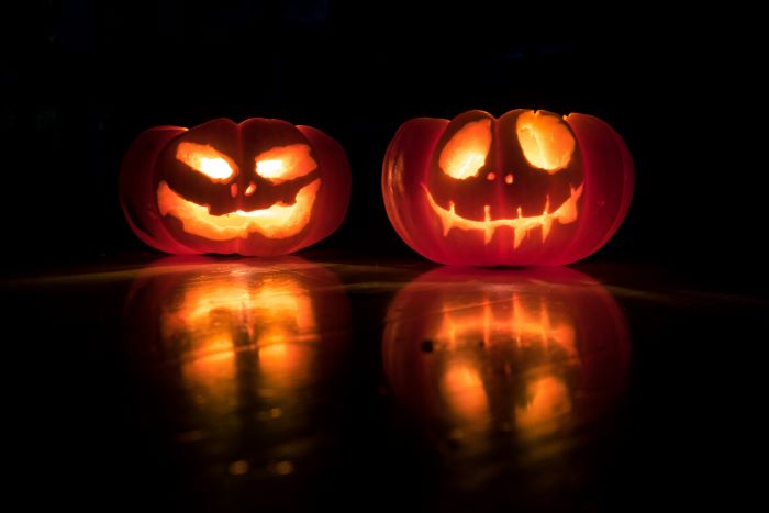 Two pumpkins with smiley faces carved onto them