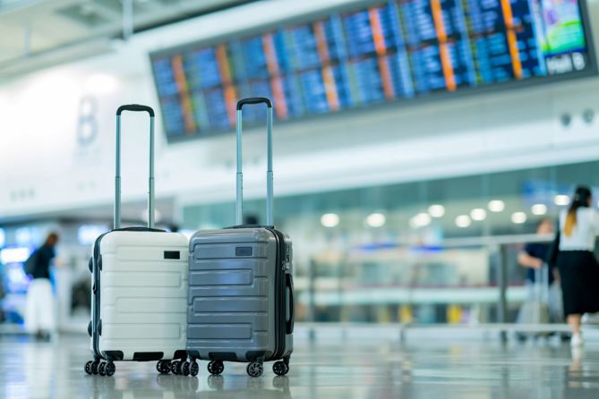 Two suitcases at an airport terminal